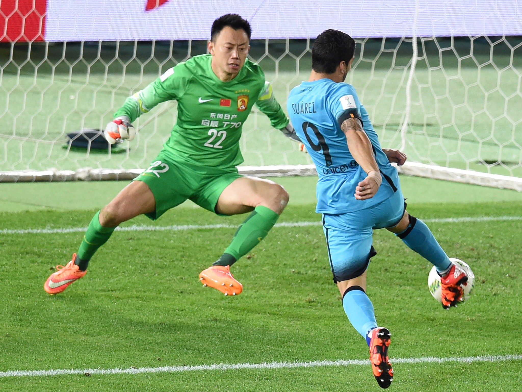 Luis Suarez scores one of his three goals for Barcelona against Guangzhou Evergande
