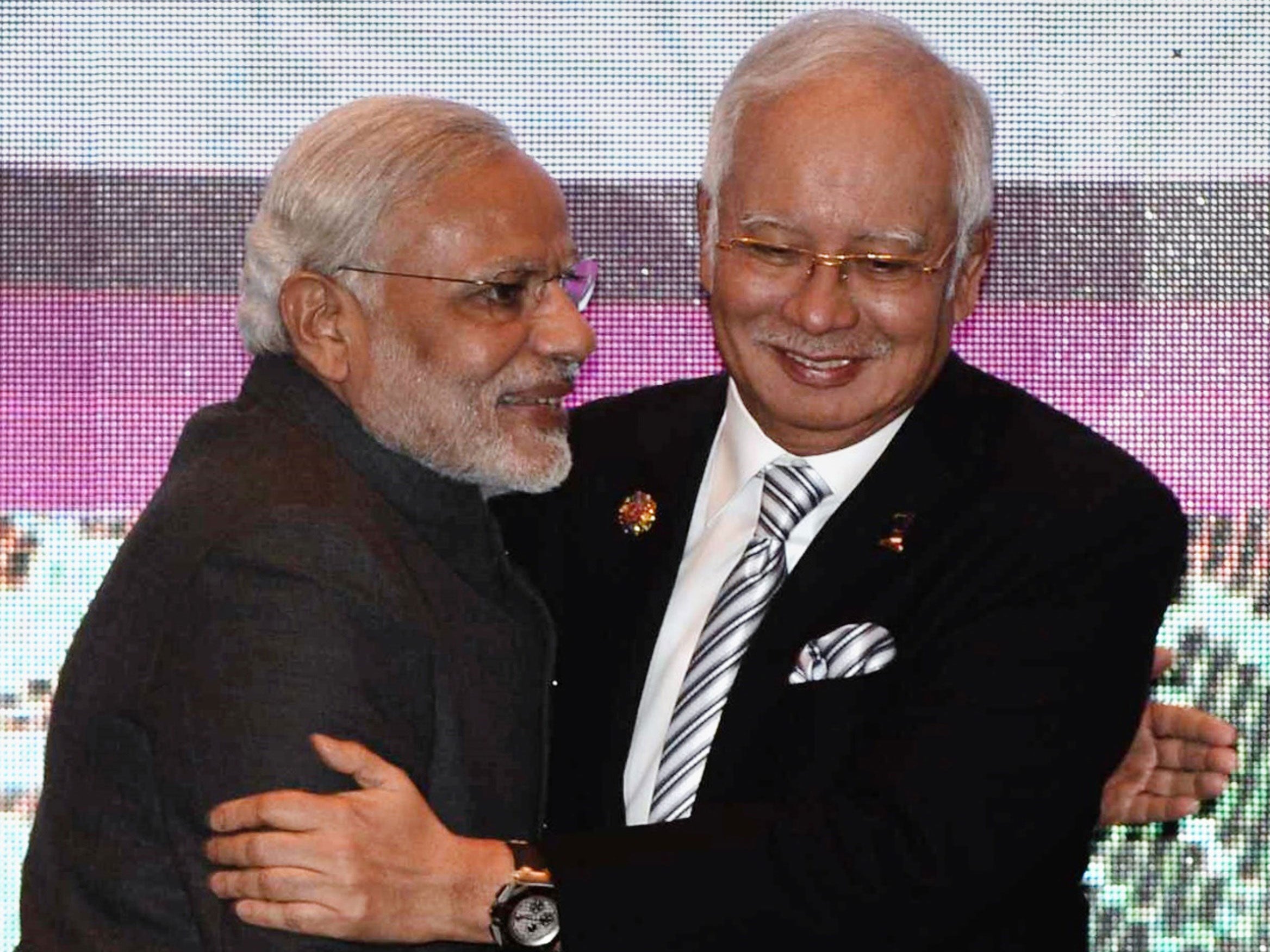 India's Prime Minister Narendra Modi (L) and Malaysia's Prime Minister Najib Razak (R) embrace as they take part in a group photo