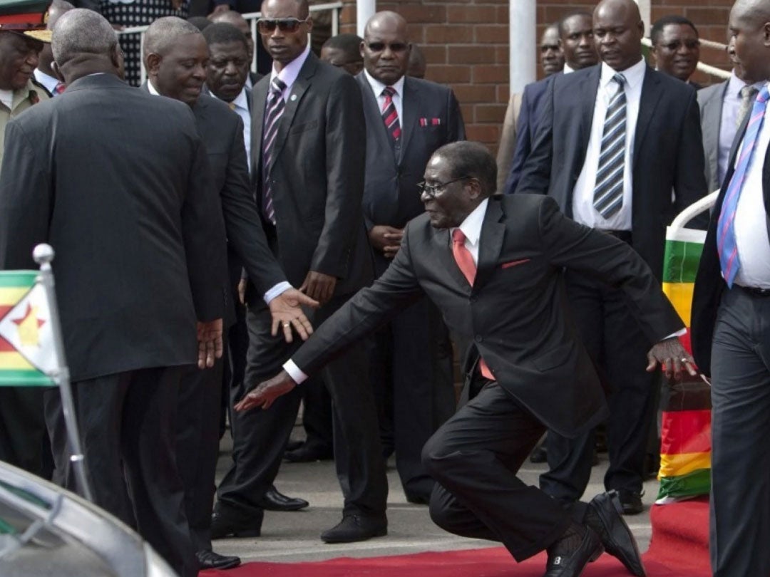 Zimbabwean President Robert Mugabe, center, falls after addressing supporters upon his return from an African Union meeting in Ethiopia, on Feb. 4. Mugabe celebrated his 91st birthday on Feb. 21