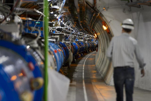 A scientist walks along a tunnel containing the Large Hadron Collider