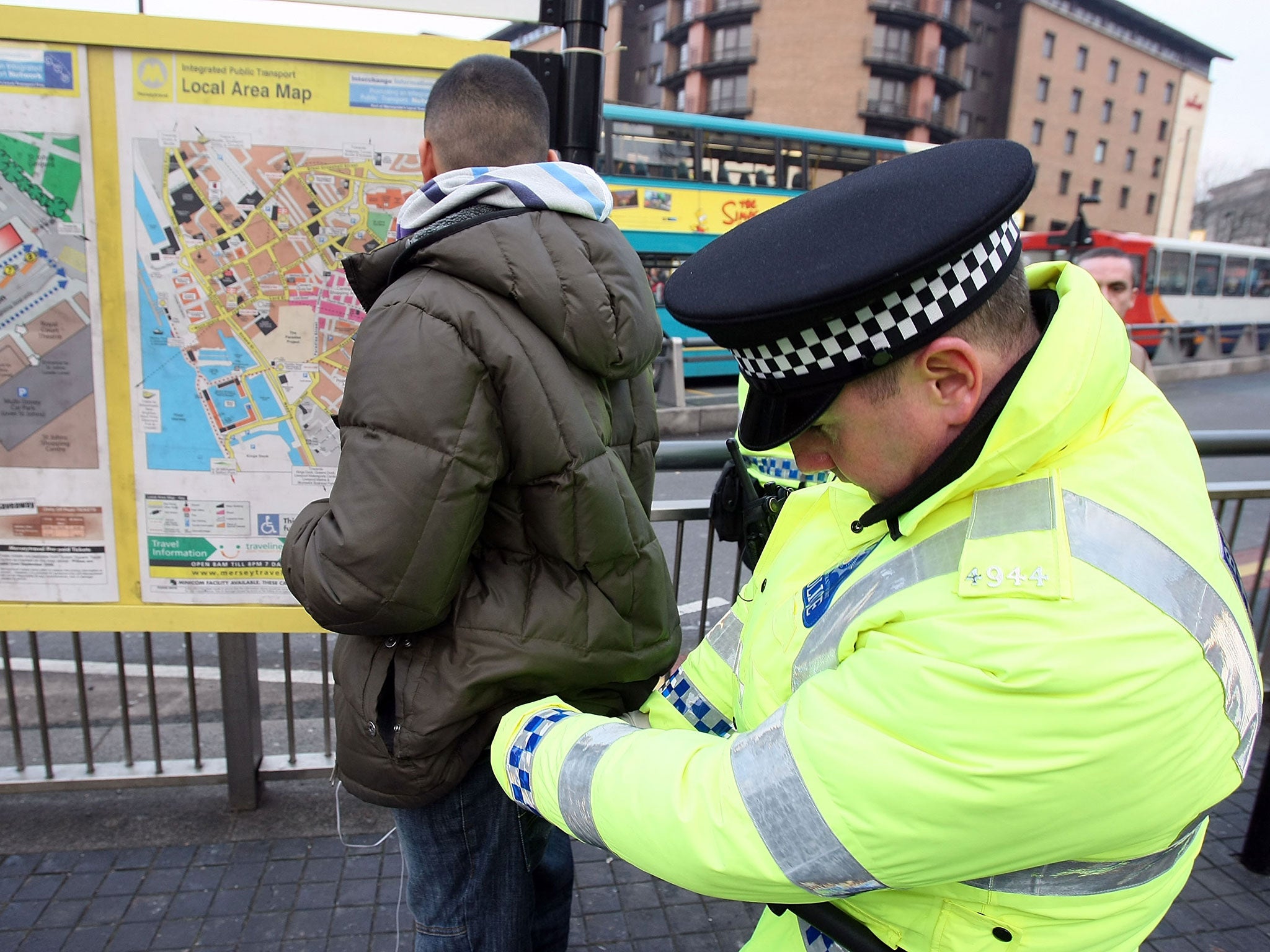 Police officers, combating potential knife-crime, stop and search people arriving in Liverpool by bus for traditional celebrations ahead of the festive period