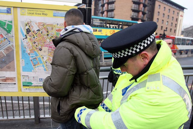 Police officers, combating potential knife-crime, stop and search people arriving in Liverpool by bus for traditional celebrations ahead of the festive period