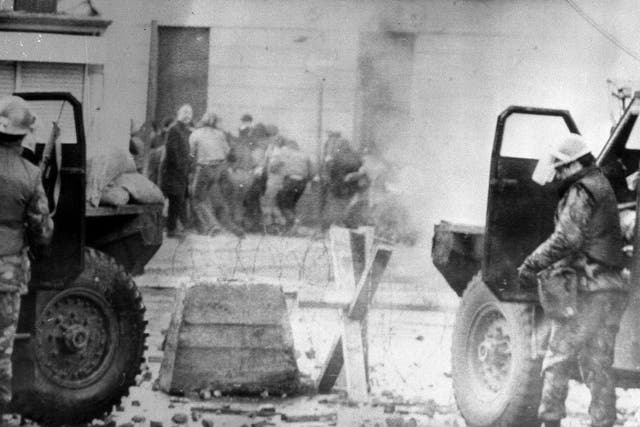 Soldiers taking cover behind their sandbagged armoured cars while dispersing rioters with CS gas during protests in Londonderry