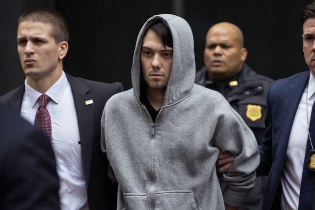 Shkreli is escorted from his building by FBI agents