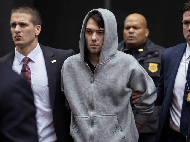 Shkreli is escorted from his building by FBI agents