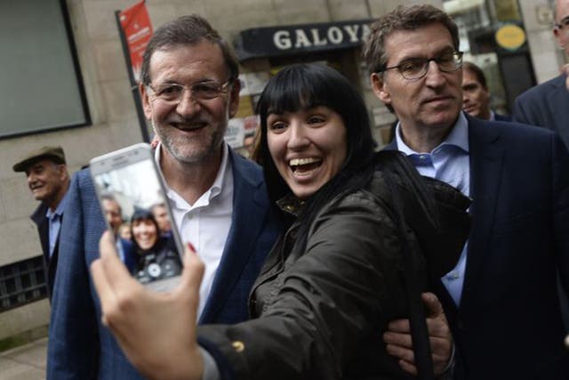 Mr Rajoy (left) poses for a selfie in the city of Vigo, in Galicia, during the election campaign last week