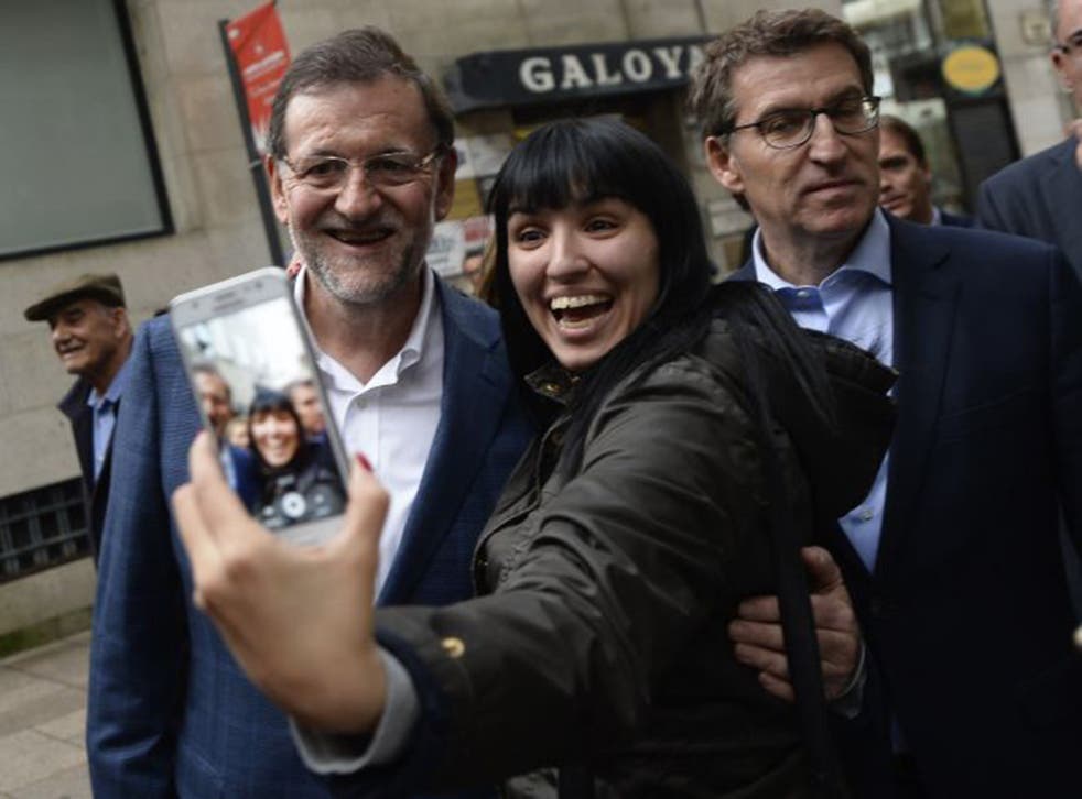 Mr Rajoy (left) poses for a selfie in the city of Vigo, in Galicia, during the election campaign last week