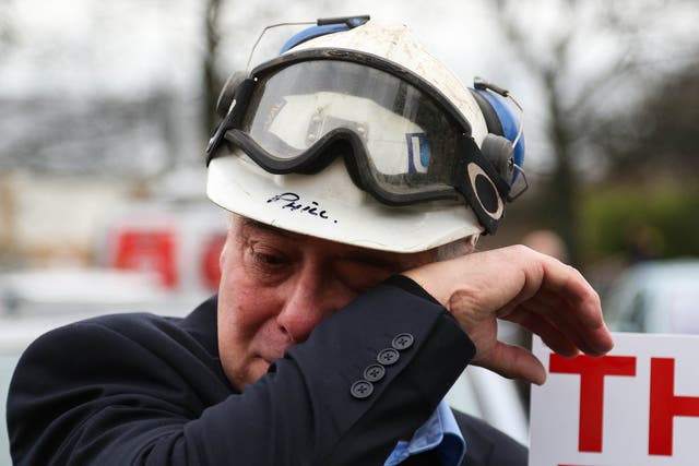 A former miner sheds a tear during a march through Knottingley, West Yorkshire, after the closure of the nearby Kellingley Colliery