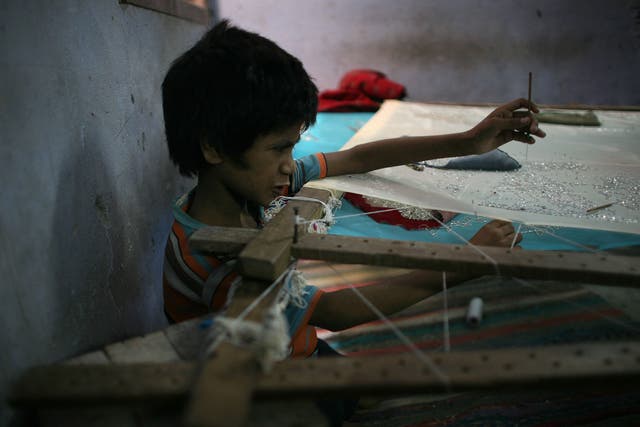 An Indian child sews sequins on to a garment in a workshop in Delhi. Currently, children under 14 are allowed to work in ‘non-hazardous’ occupations