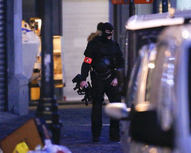 An armed police at the scene of the police raid in Laeken, Brussels on Sunday