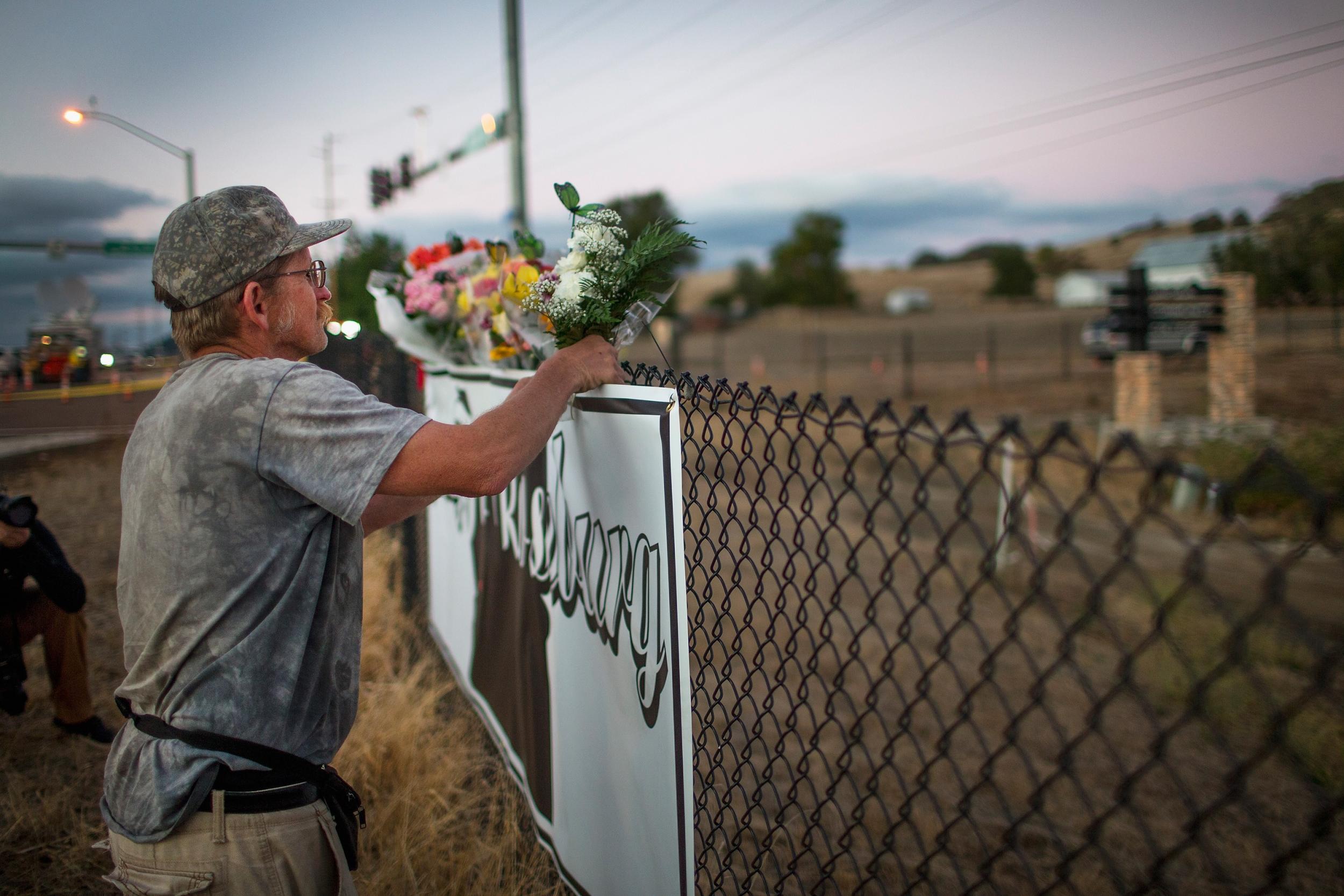 Michael Garwood leaves flowers at a small memorial near Umpqua Community College