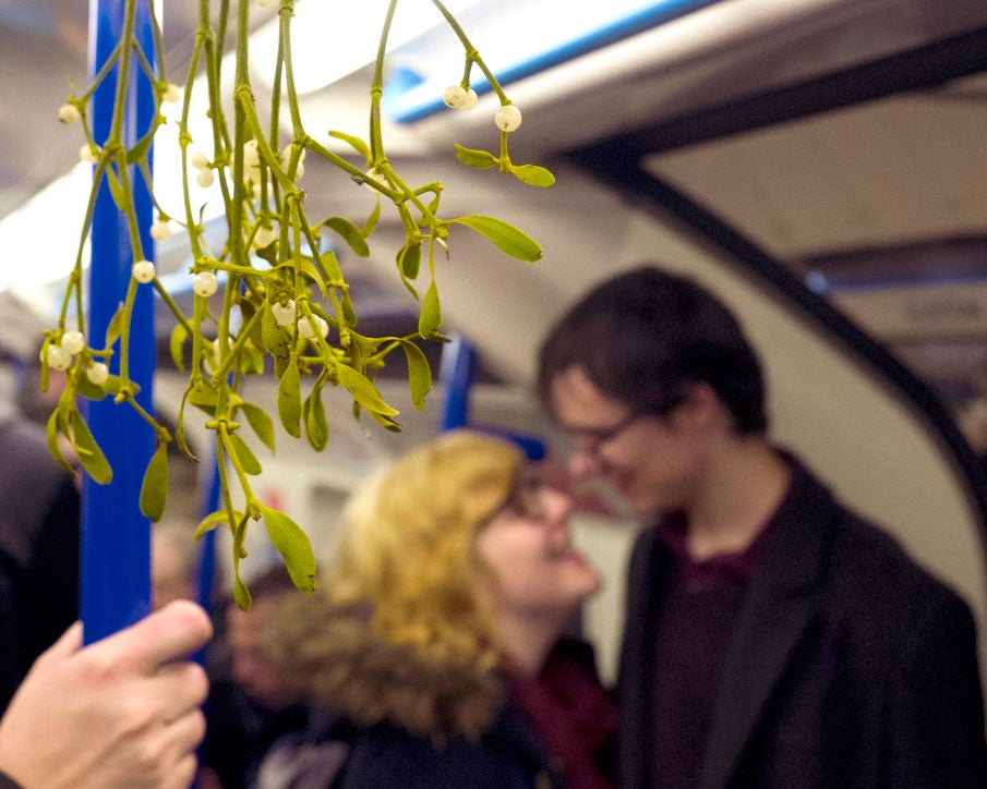 Commuters under mistletoe on the London Underground