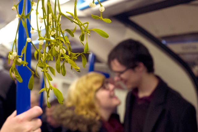 Commuters under mistletoe on the London Underground