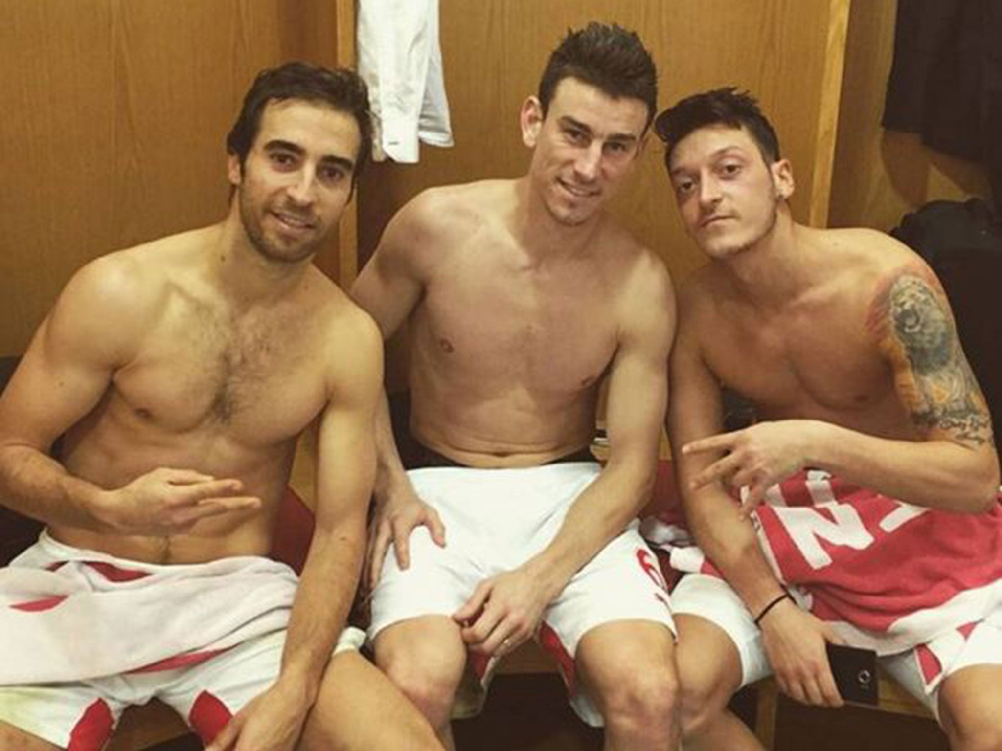 Mesut Ozil celebrates with Laurent Koscielny and Mathieu Flamini after Arsenal's win over Manchester City
