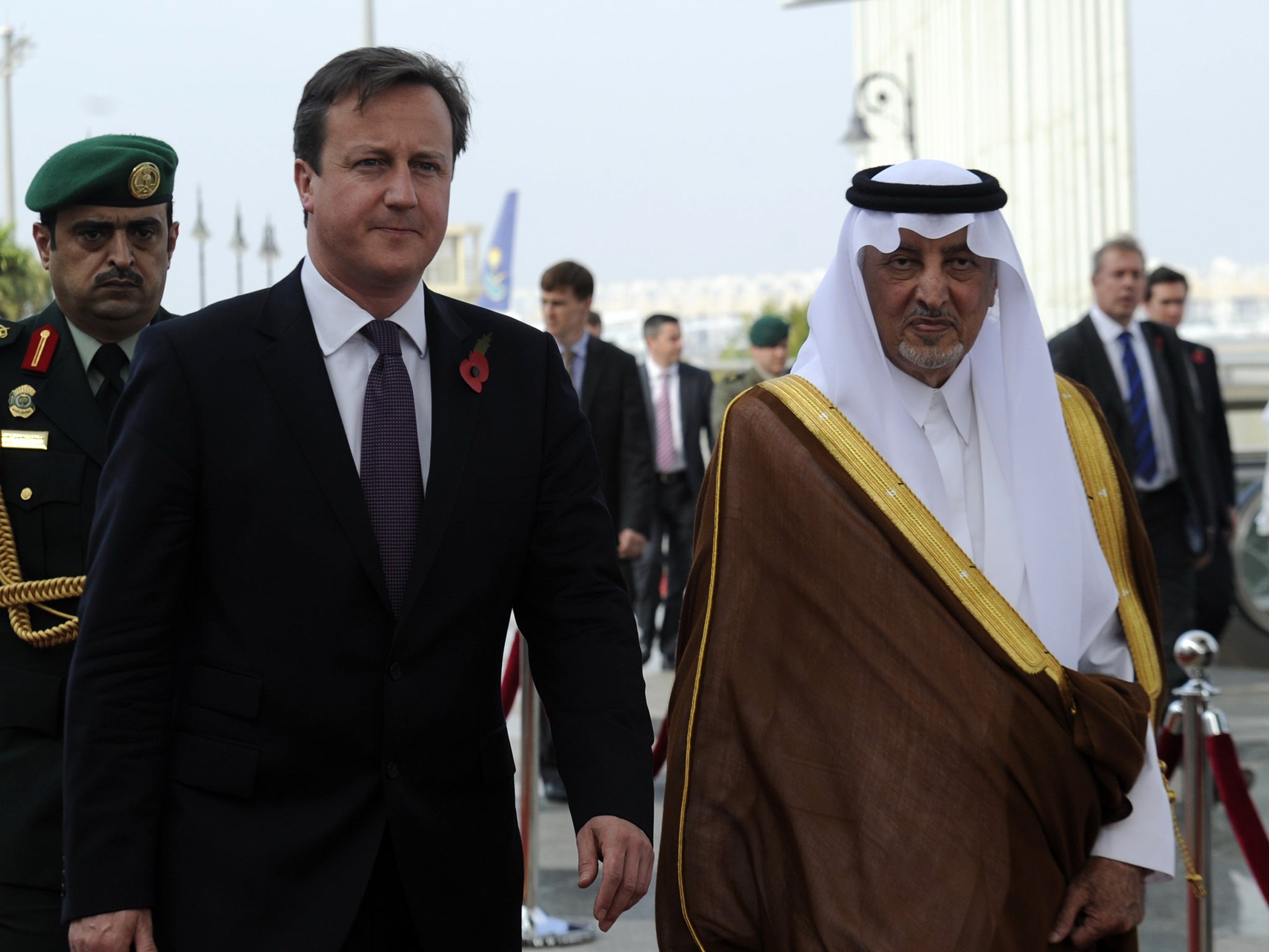 Prince Khalid bin Faisal bin Abdulaziz welcomes British Prime Minister David Cameron (L) as he arrives in Jeddah on November 6, 2012