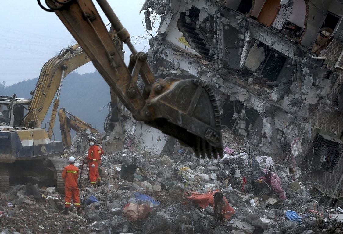 Rescuers search for potential survivors near a damaged buildings following a landslide at an industrial park in Shenzhen