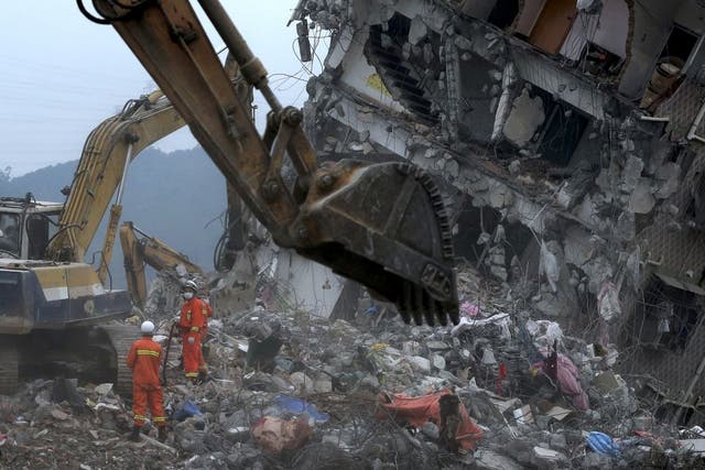 Rescuers search for potential survivors near a damaged buildings following a landslide at an industrial park in Shenzhen