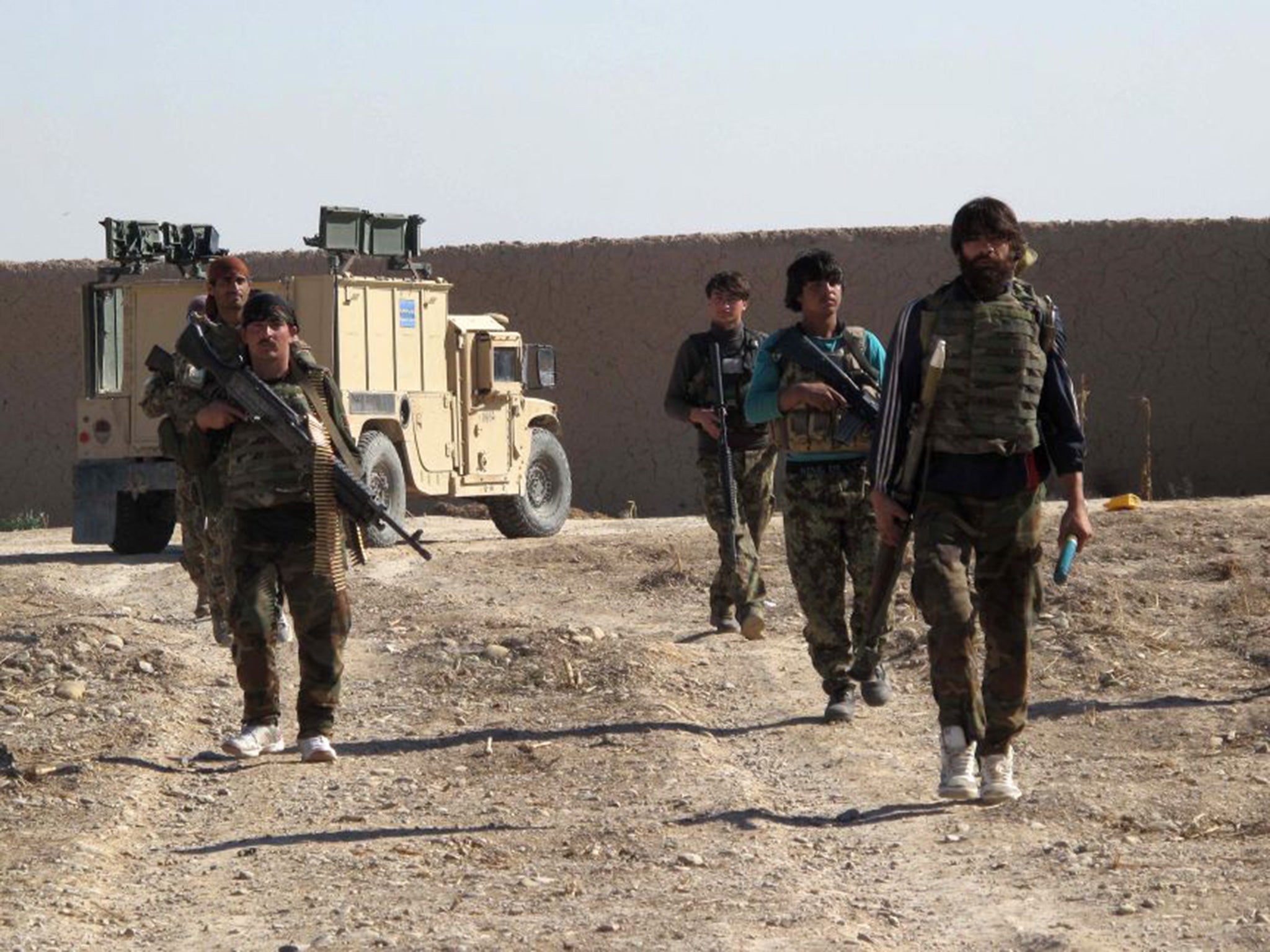 Afghan National Army (ANA) soldiers walk in Helmand on December 21, 2015