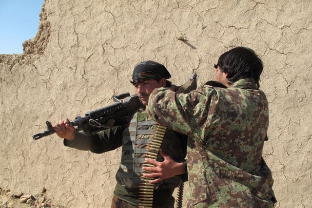 Afghan National Army (ANA) soldiers adjust their equipment in Helmand on December 21, 2015.