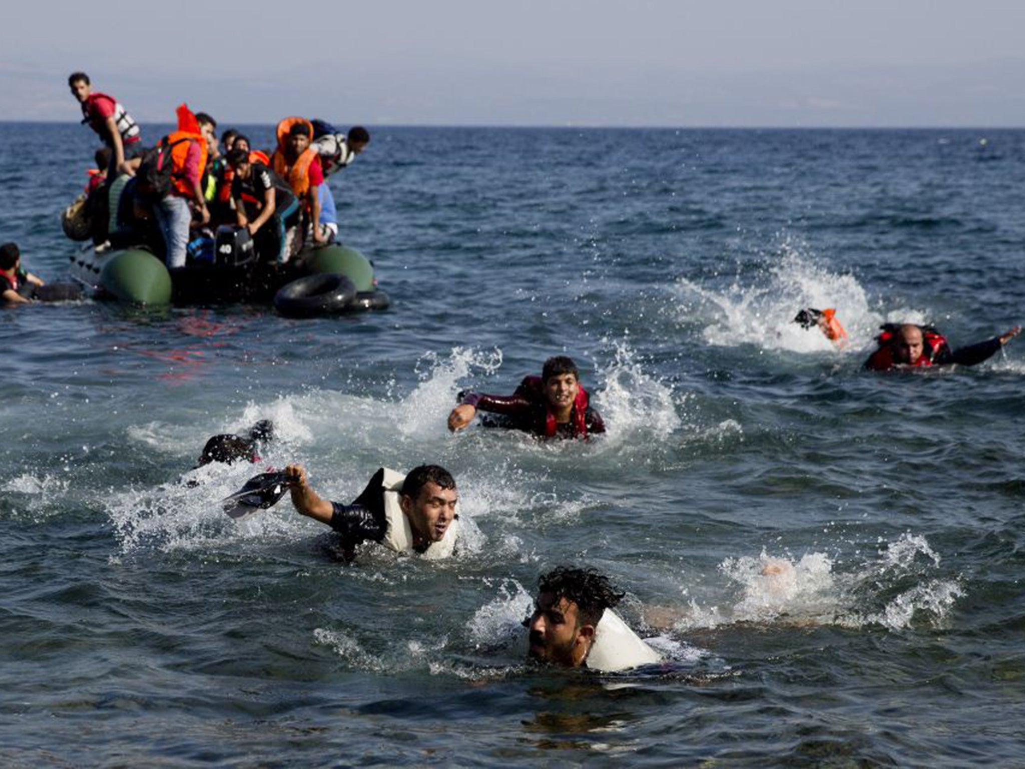 Refugees swim to the shores of the island of Lesbos after their boat stalled in the Aegean sea