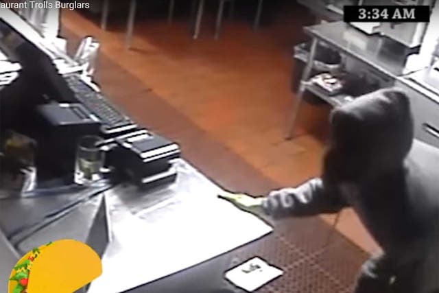 One of the thieves examines the - empty - till