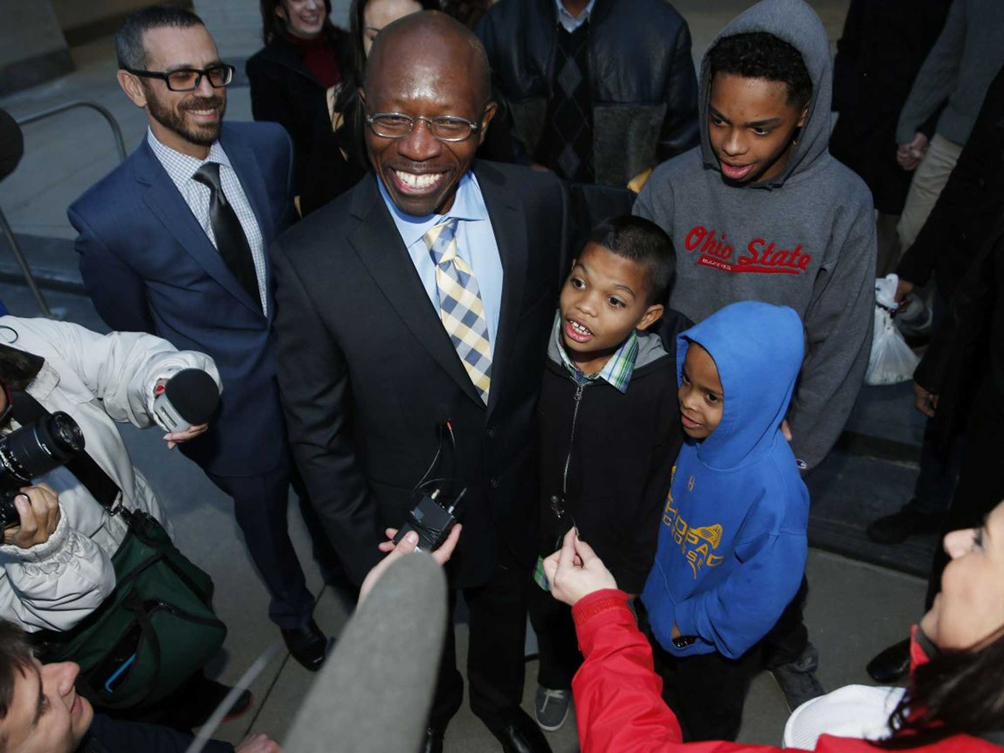 Clarence Moses-EL stands with three of his grandchildren after his release from the Denver County jail