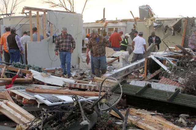People inspect a storm-damaged home in the Roundaway community near Clarksdale, Mississippi