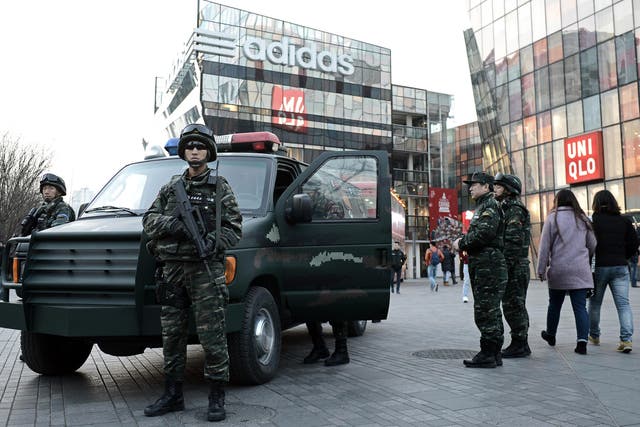 Armed Chinese policemen stand guard in the popular shopping and nightlife area of Sanlitun in Beijing