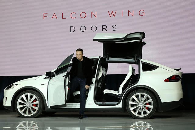 Tesla CEO Elon Musk steps out of a Tesla Model X SUV at the launch event in September 2015