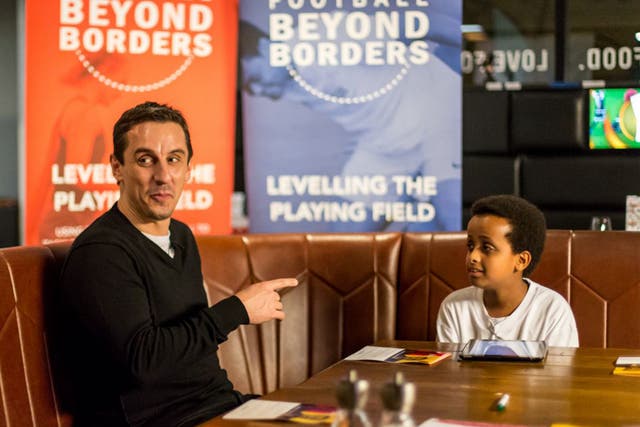 Gary Neville is interviewed by a young boy at a workshop organised by the charity Football Beyond Borders