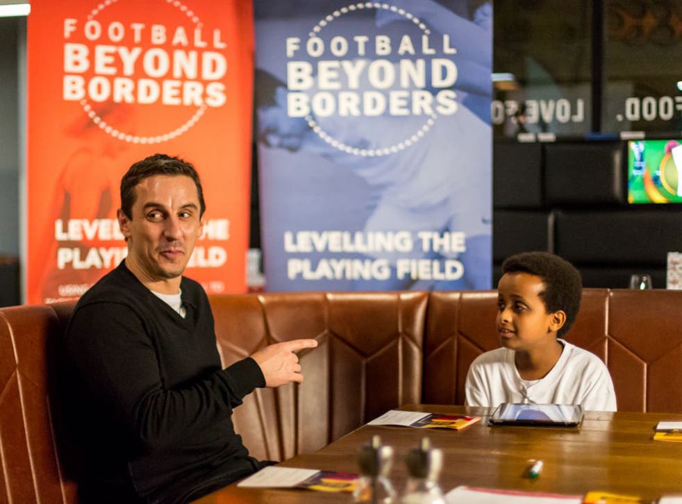 Gary Neville is interviewed by a young boy at a workshop organised by the charity Football Beyond Borders