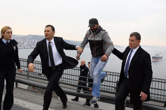 Turkish President Recep Tayyip Erdogan's bodyguards escort the man away from the edge of the bridge
