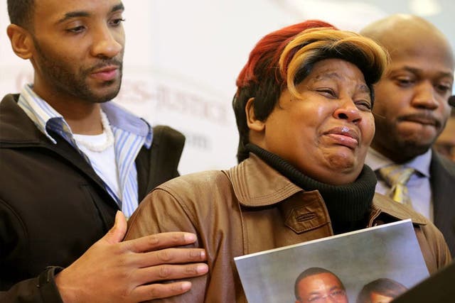 Cynthia Daniels is comforted by her son Bobby Daniels Jr. during a news conference about the death of  her husband, Bobby Daniels