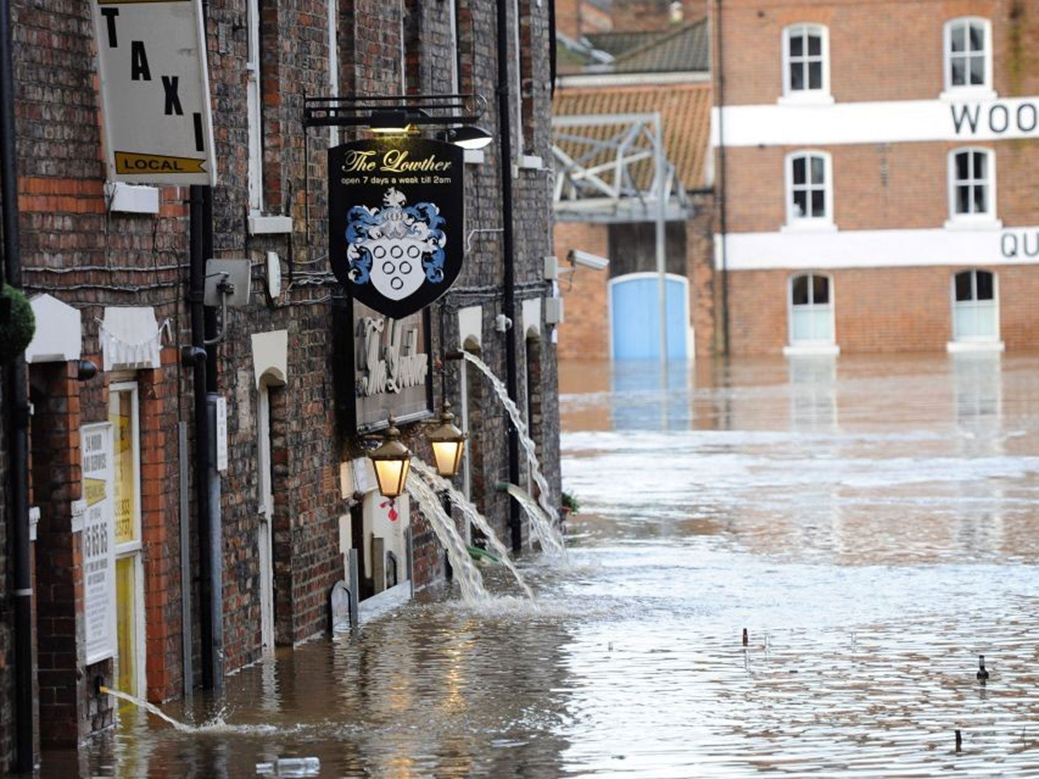 Water runs out of the Lowther pub in York on 27 December after the River Ouse bursts its banks in York city centre.