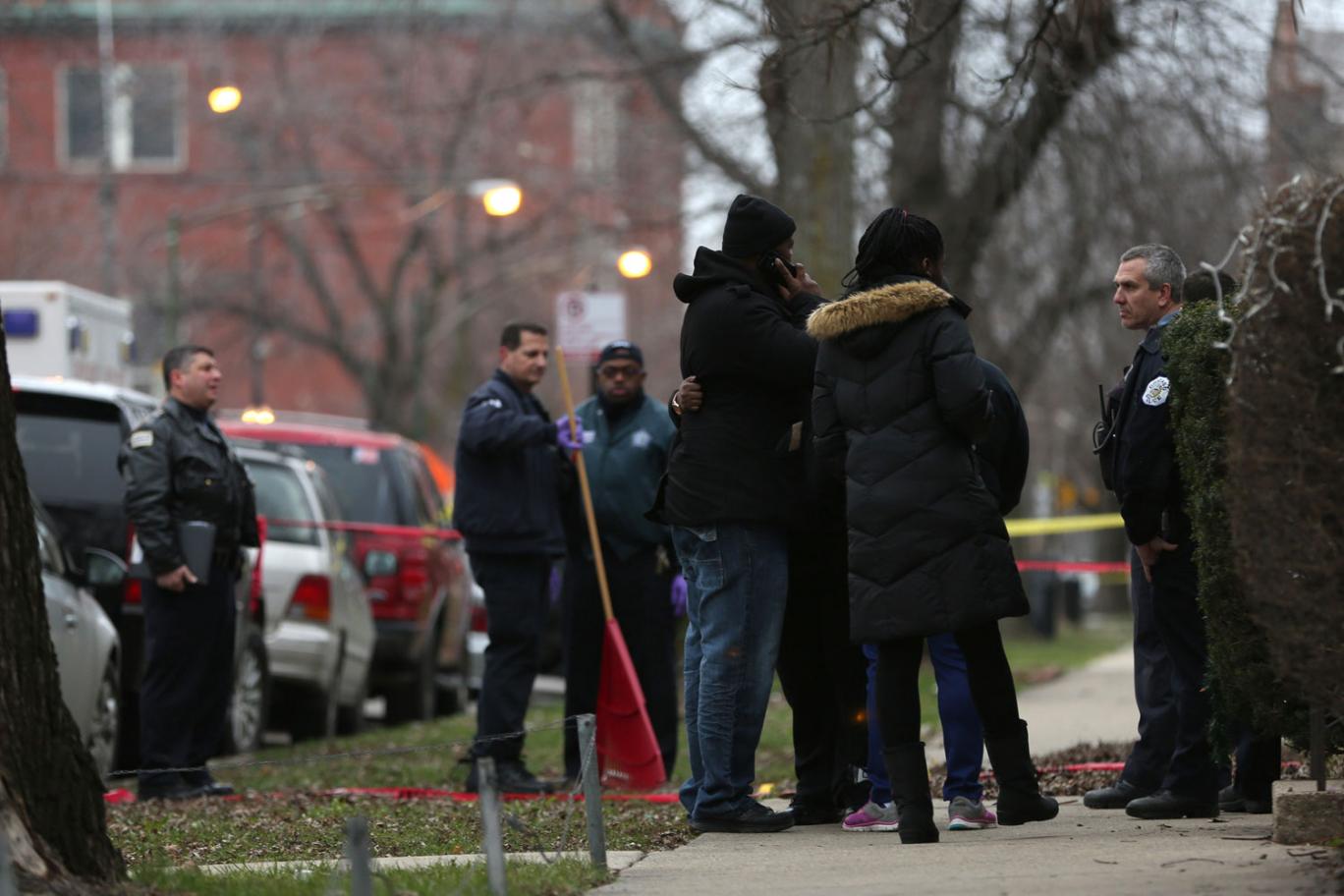 Police officers talk with relatives of one of the two people killed by a police officer in Chicago