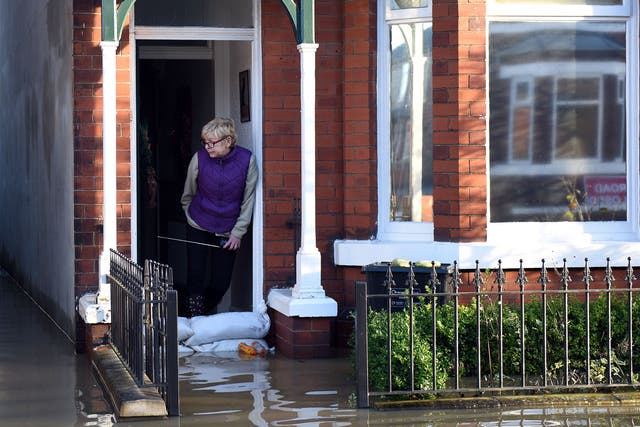 A woman looks out from a flooded property adjacent to the River Foss which burst its banks in York, northern England, on 27 December , 2015