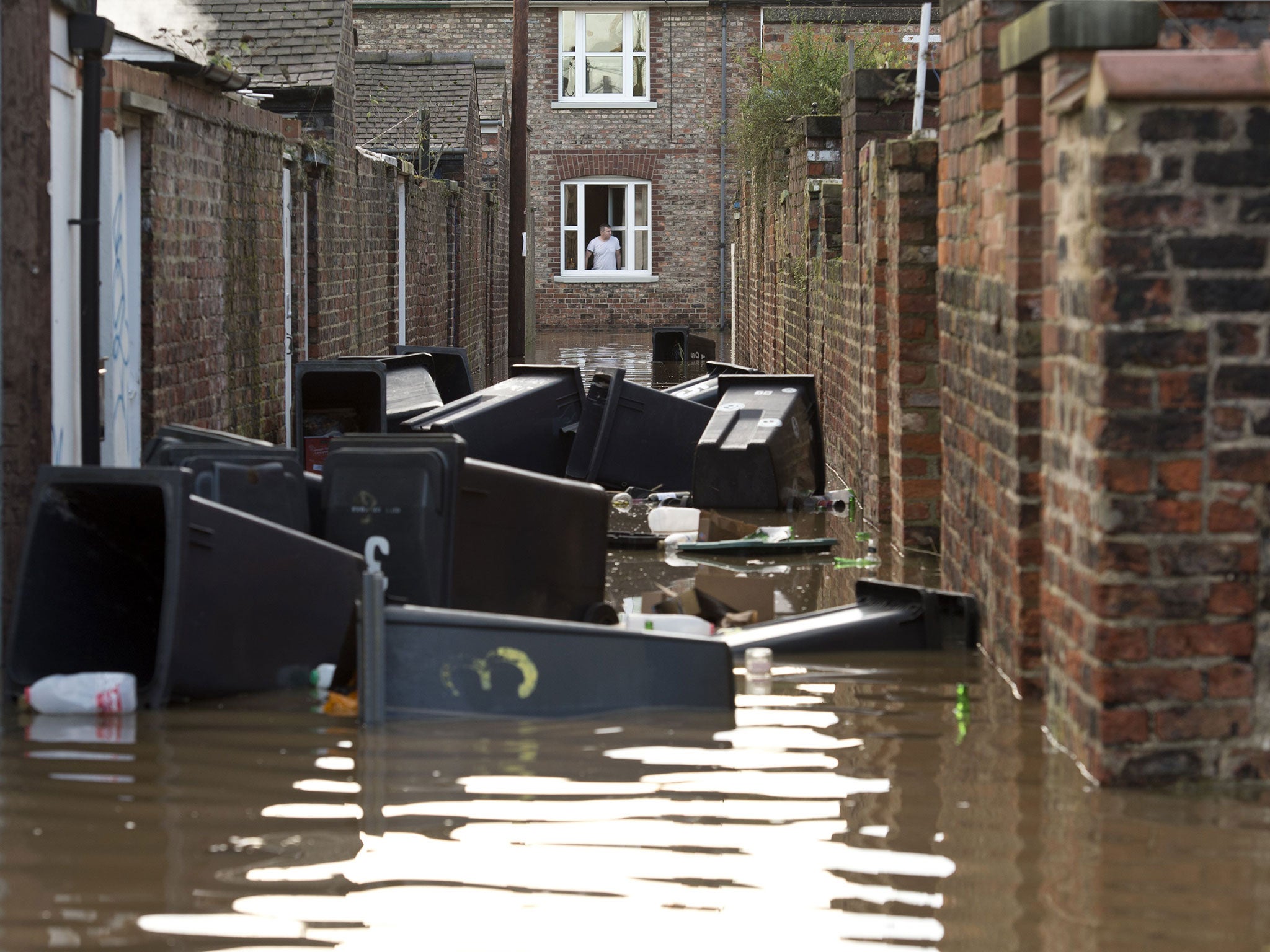 An alleyway filled with floating garbage bins after the adjacent River Ouse burst it's banks in York