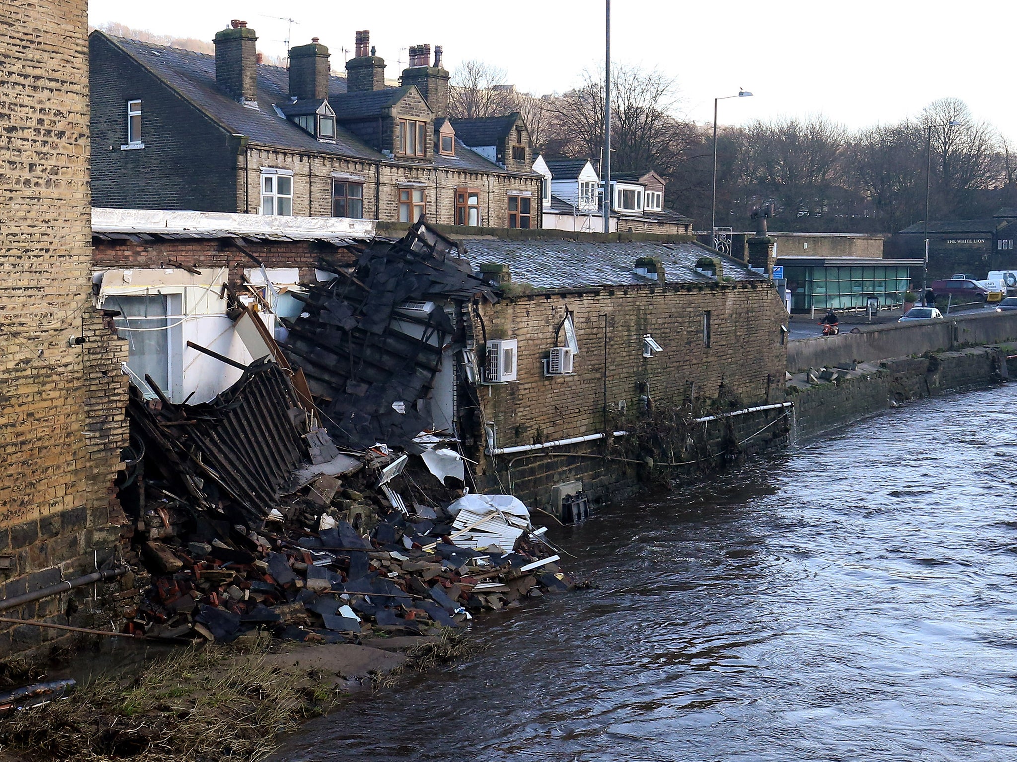 Part of a building collapsed into the river after yesterday's floods in Mythelmroyd, England