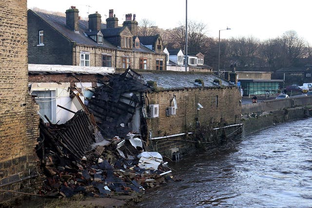 Part of a building collapsed into the river after yesterday's floods in Mythelmroyd, England