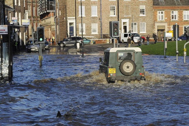A Land Rover is driven through floodwater in York city centre, after the River Ouse and the River Foss burst their banks.
