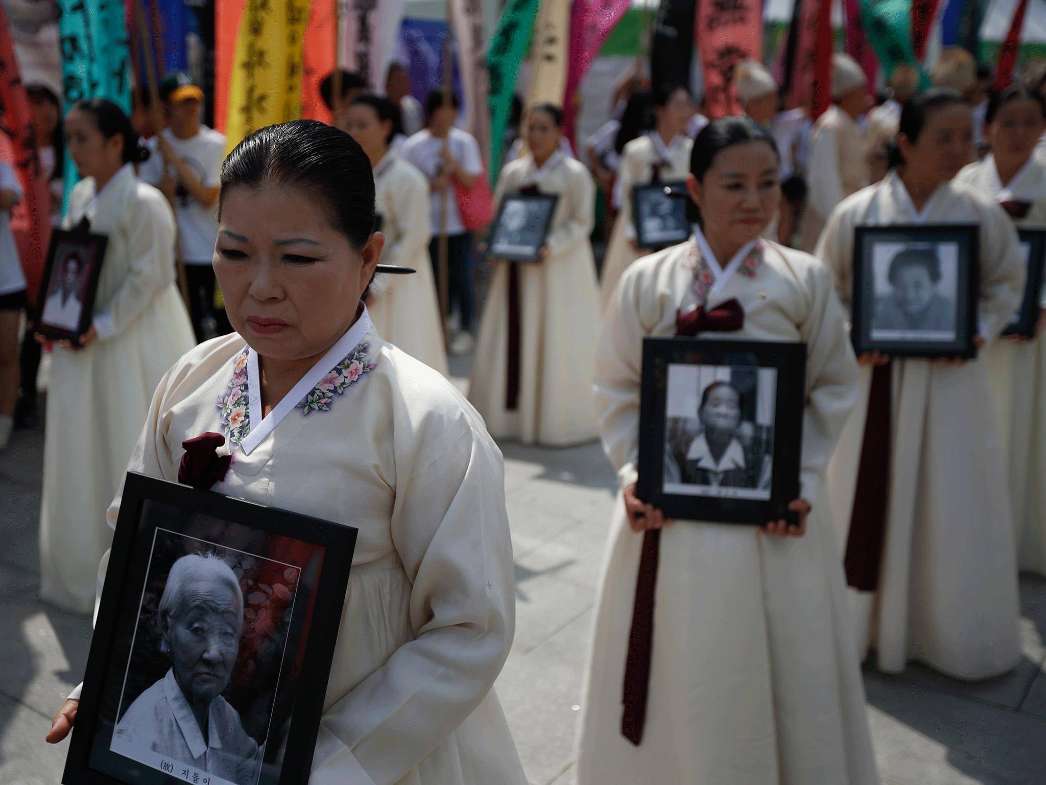 Participants carry the portraits of Korean women who were made sex slaves b...