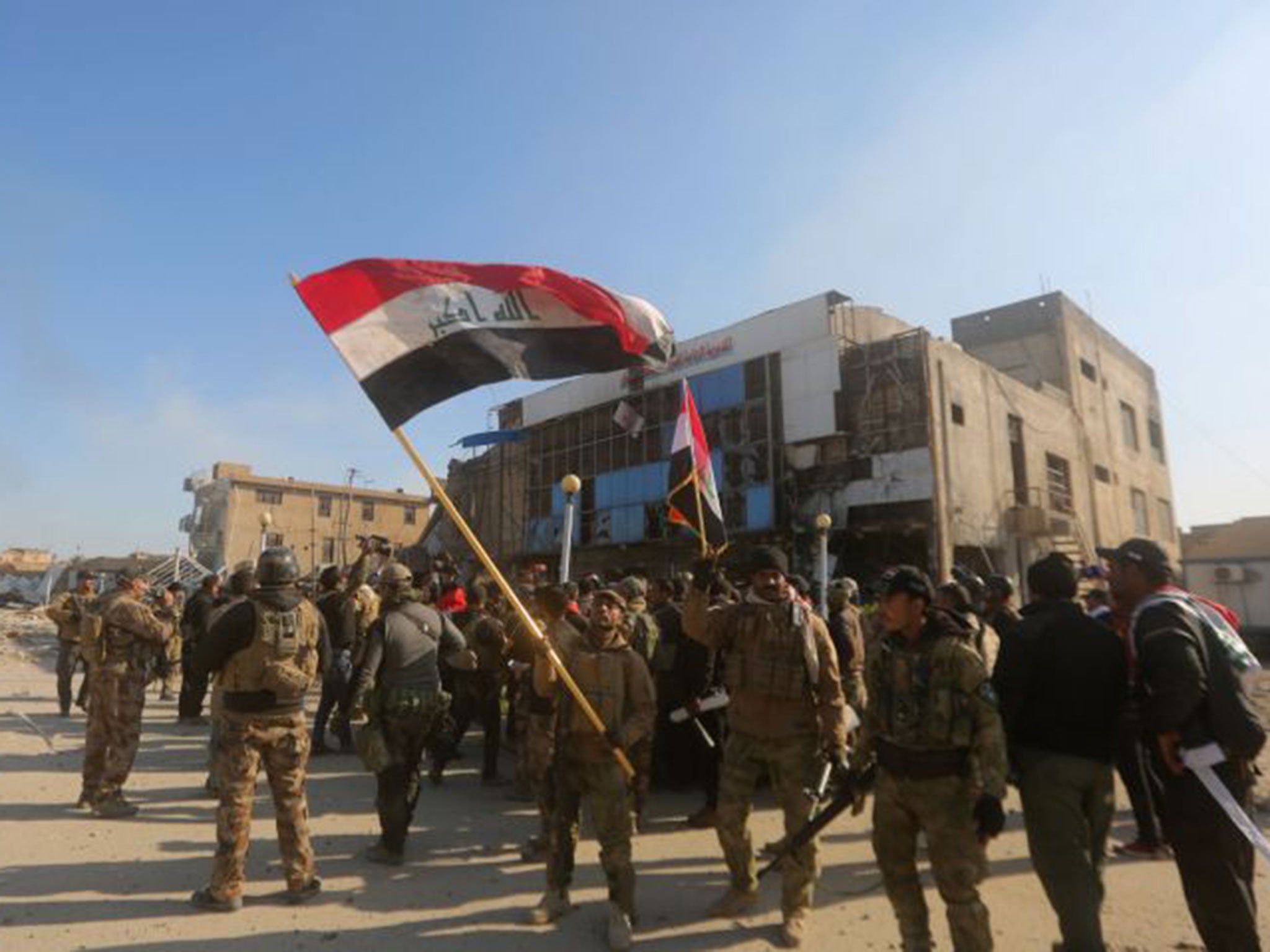 Iraqi security forces fly the national flag after they recaptured Ramadi