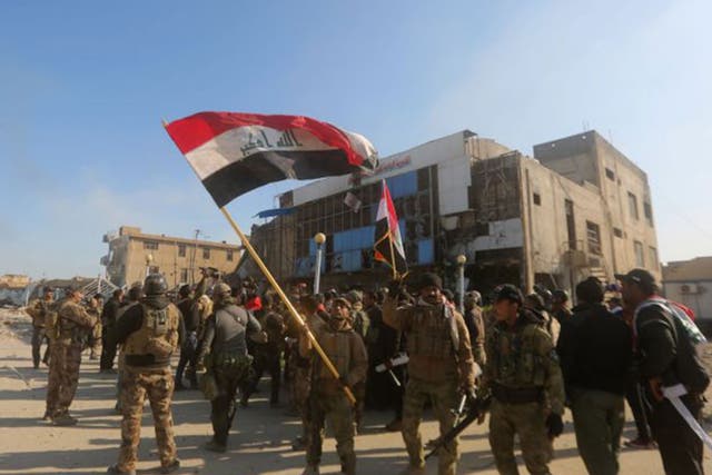 Iraqi security forces fly the national flag after they recaptured Ramadi