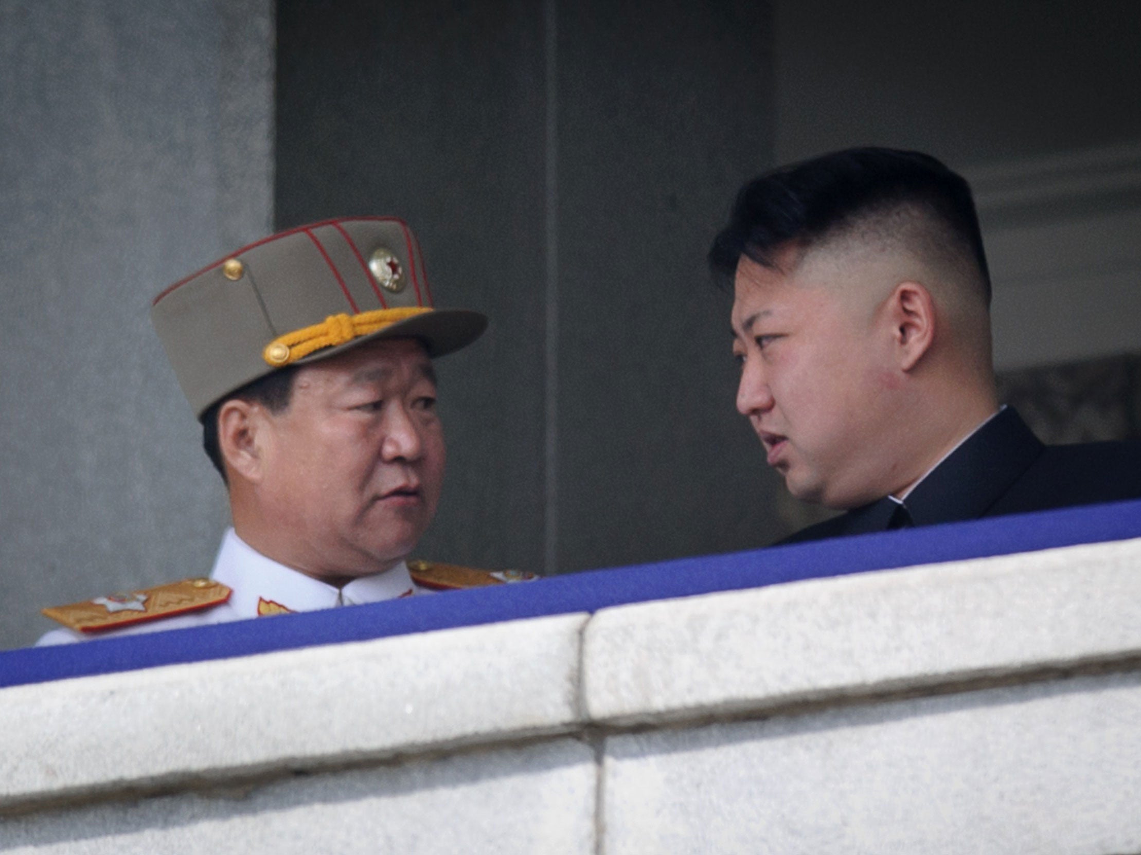 Choe Ryong-Hae (left) talking with North Korean leader Kim Jong-Un (right) attending a military parade in Pyongyang