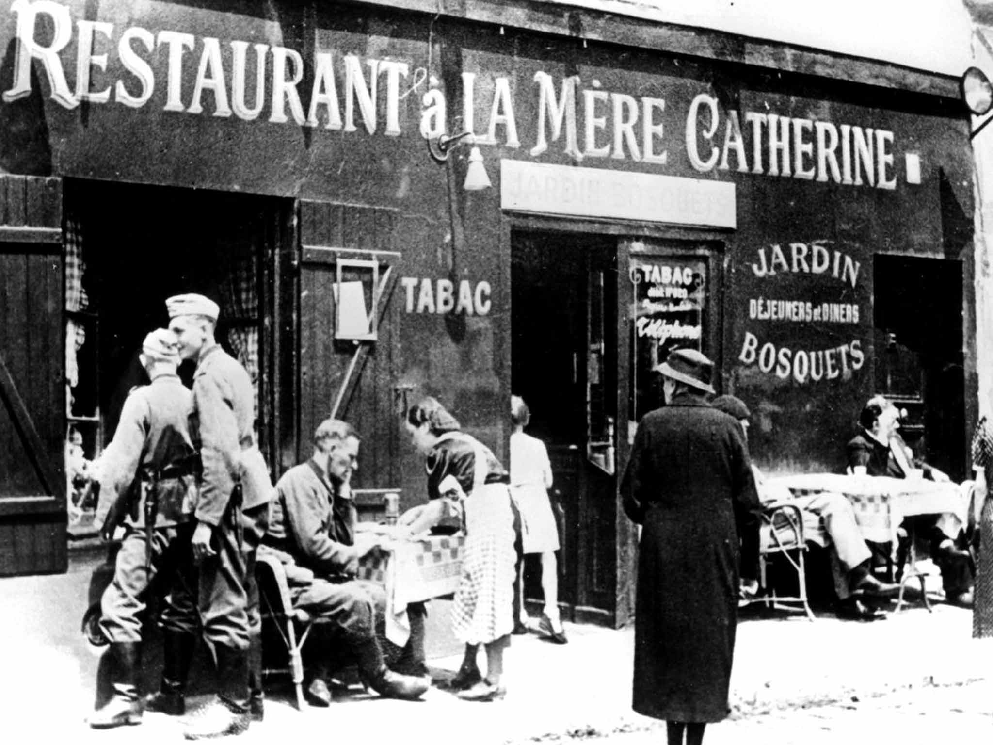 &#13;
Constant terror: German soldiers at a restaurant in Paris shortly after the city fell to the Nazis in 1940 &#13;