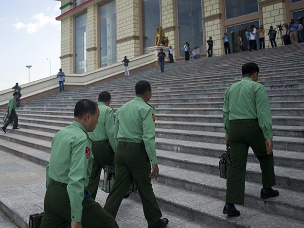 Military officials can be seen wearing the light green uniform
