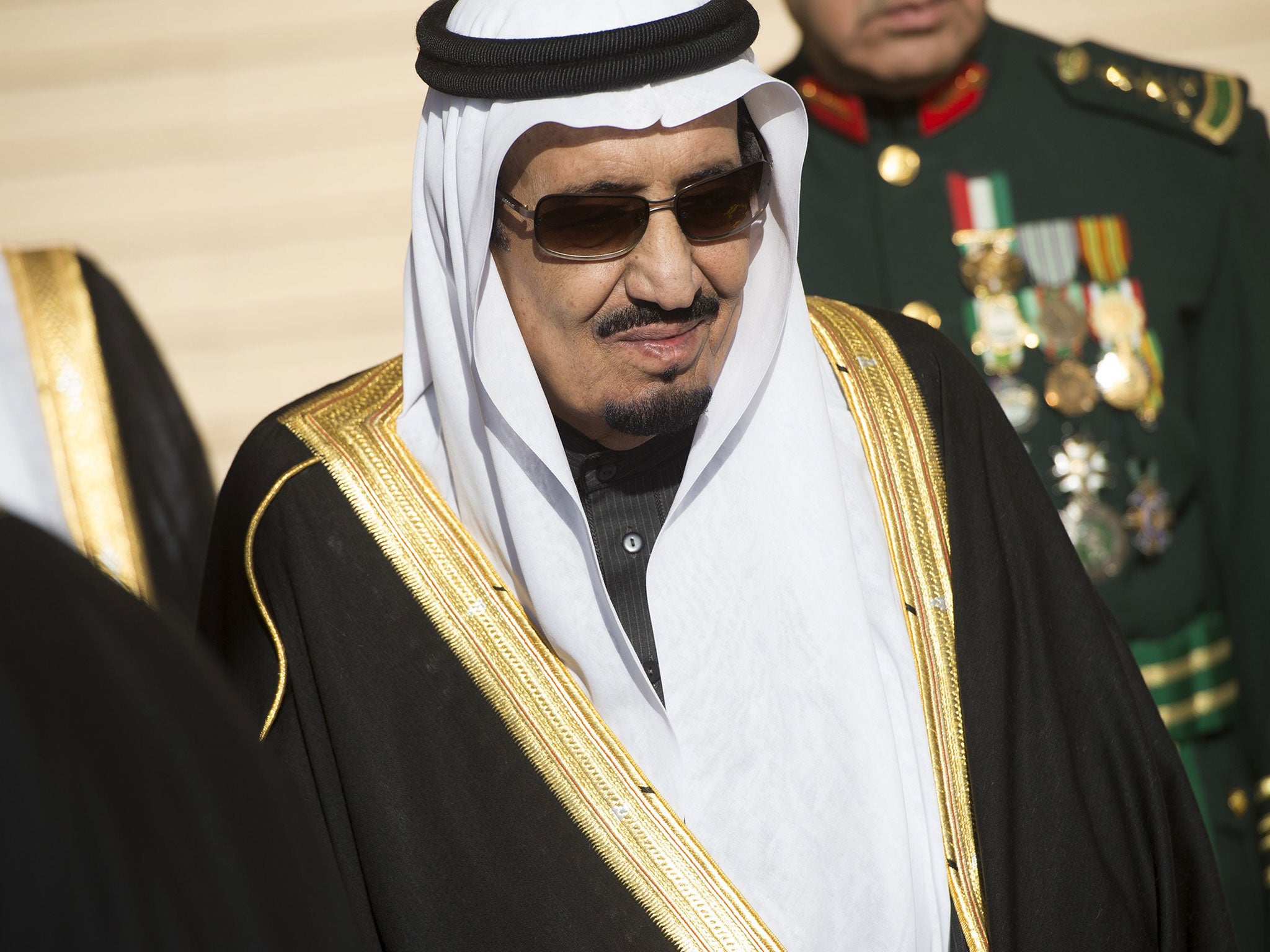 King Salman stands during the arrival of US President Barack Obama and First Lady Michelle Obama in Riyadh