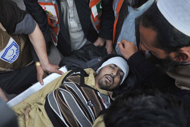 Pakistani paramedics transport a bomb blast victim to a hospital in Peshawar