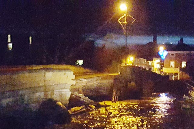 Part of the bridge has collapsed into the swollen River Wharfe running beneath it, exposing gas pipes