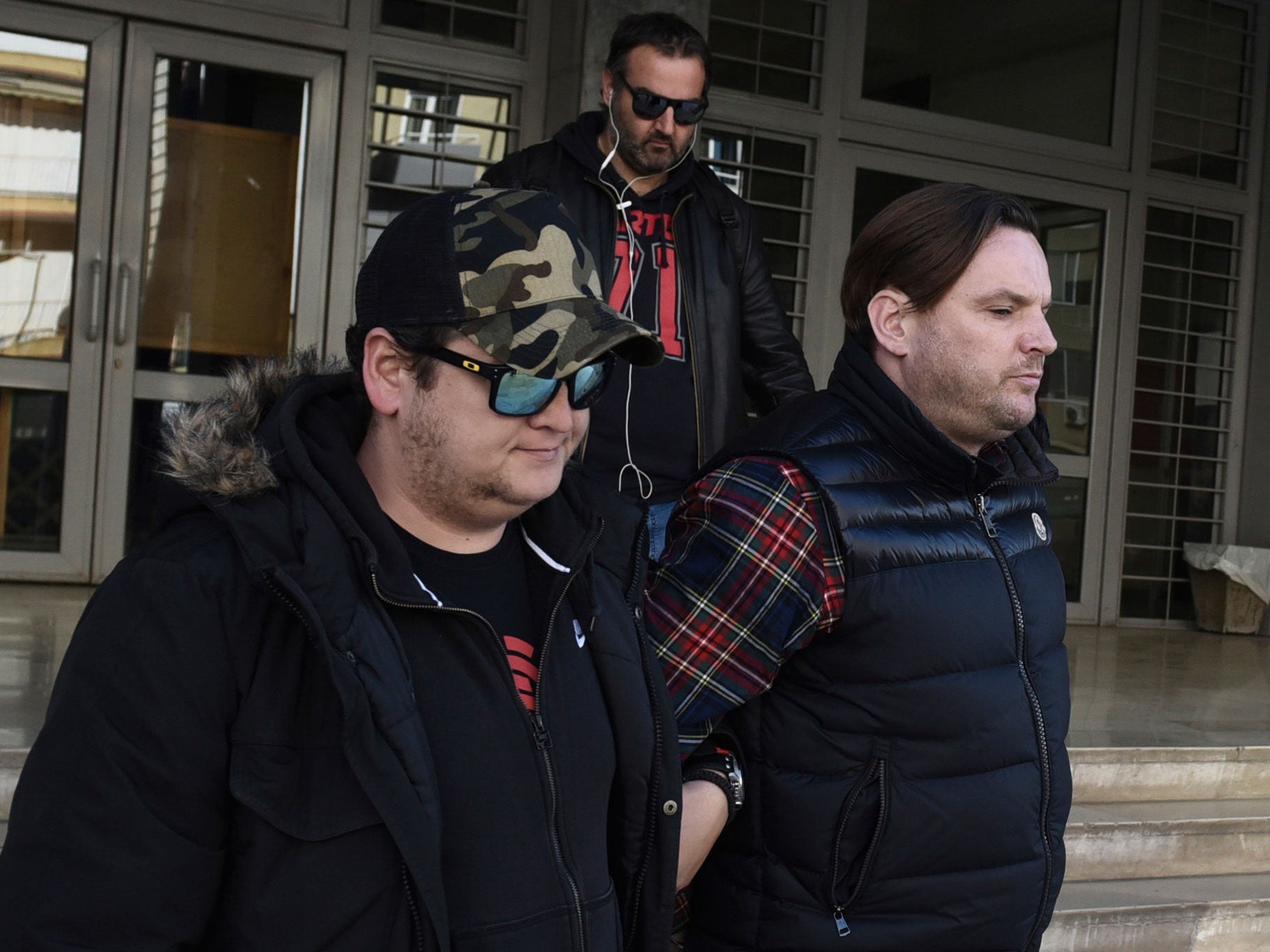 Simon Dutton, 39, right, is escorted by police officers as he leaves a courthouse at the northern Greek city of Thessaloniki